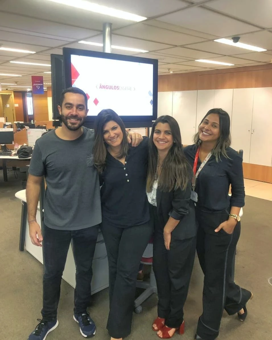 Equipe em escritório da Losango com tela de comunicação interna